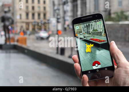 Montreal, CA - August 12, 2016: Closeup of a man playing Pokemon Go on a smart phone. Stock Photo