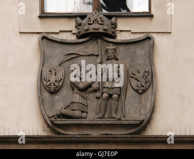 Holy Roman Emperor Charles IV kneeling in front Saint Wenceslas of Bohemia. Emblem of the Charles University depicted on the Karolinum (Collegium Carolinum) in the Old Town in Prague, Czech Republic. Stock Photo