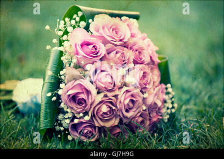 Wedding bouquet of pink roses lying on the ground Stock Photo