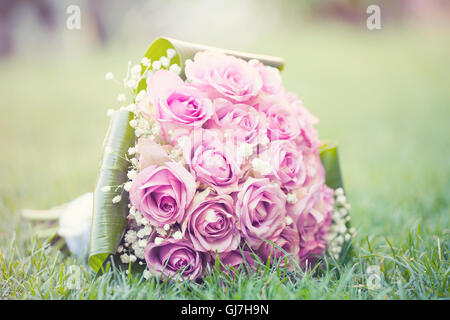 Wedding bouquet of pink roses lying on the ground Stock Photo