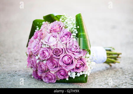 Wedding bouquet of pink roses lying on the ground Stock Photo