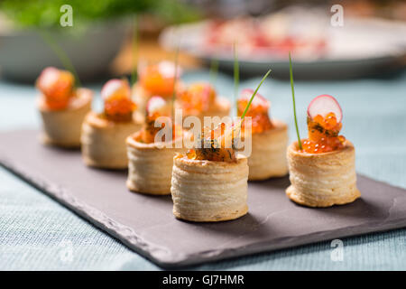 Delicious appetizers with graved salmon and golden caviar served in puff pastry towers Stock Photo