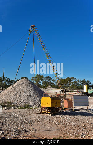 Opal mining shaft with mullock heaps and mining equipment in the ...