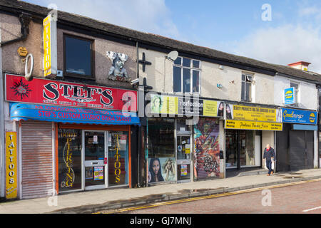 Shops on Newport Street, on the fringe of Bolton town centre, mostly specialising in aspects of the cosmetic body image trade. Stock Photo