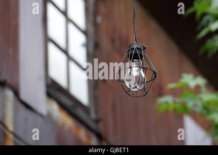 Dirty old light bulb in abandoned barn Stock Photo