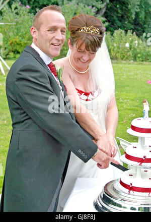 Mature, Happy, Bride and Groom Cutting the Cake at their Wedding Reception. Stock Photo