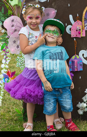 Burley, Hampshire, UK 13 August 2016. Young girl dressed as fairy and boy as crocodile standing against the wishing tree at the New Forest Fairy Festival, Burley, Hampshire, UK in August  Credit:  Carolyn Jenkins/Alamy Live News Stock Photo