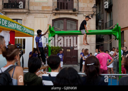 Barcelona, Catalonia, Spain. 13th Aug, 2016. In the Gothic Quarter of Barcelona a young boy tries to maintain balance at the top of La Cucanya or greasy pole during the festivities for Sant Roc Festival (the oldest popular festival in the city). This Cucanya, or horizontal greasy pole, has over 100 years and every festival afternoon the bravest children can climb up and try to get the prize. Credit:  Jordi Boixareu/ZUMA Wire/Alamy Live News Stock Photo