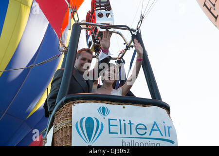 Bristol,UK,14th August 2016,Newlywed couple, Marcus Forsey and Melissa Forsey, wave from the basket as they lift off in a Royal Navy Balloon at the Bristol International Balloon Fiest Credit: Keith Larby/Alamy Live News Stock Photo