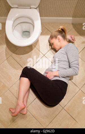 Woman Lying On Bathroom Floor With Newspaper Stock Photo 8572286