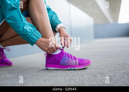 MODEL RELEASED. Woman tying laces on trainers. Stock Photo