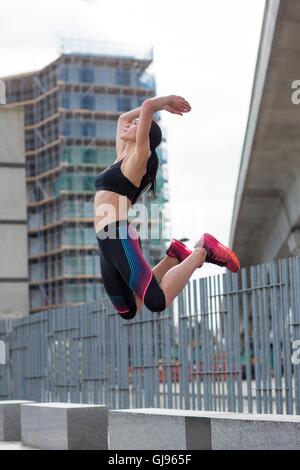 MODEL RELEASED. Young woman jumping mid air. Stock Photo