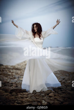 Outdoor portrait of a beautiful sad young woman in white dress Stock Photo