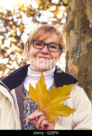 Mature blonde woman enjoying autumn weather Stock Photo