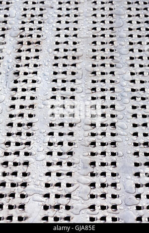 Water drops on perforated metal surface Stock Photo