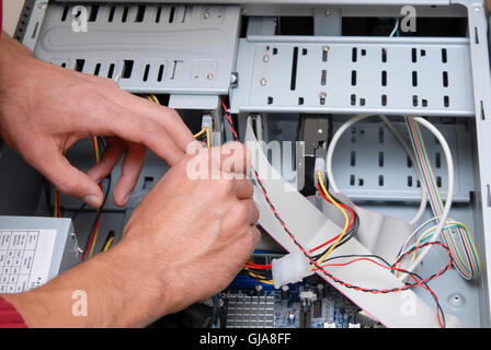 Male computer technician working on the inner parts of a PC Stock Photo
