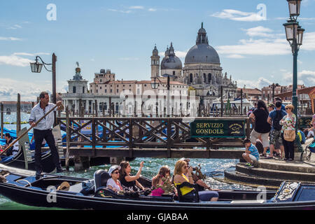 Gondola ride in Venice, with the Church of Santa Maria della Salute behind, Veneto region, Italy. Stock Photo