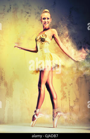 Beautiful ballerina in yellow tutu on point Stock Photo