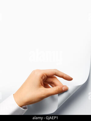 A hand turning a blank white page Stock Photo