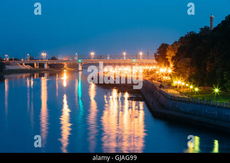 The Scenic Summer Evening View Of Sozh River, Illuminated Embankment And Ancient Greenwood Park In Gomel, Homiel, Belarus. Blue Stock Photo