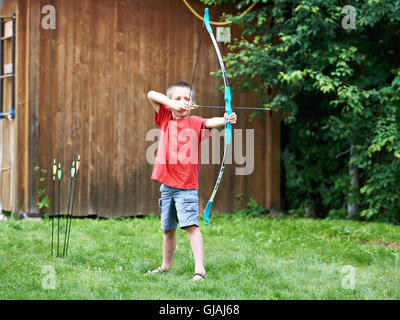Little archer with bow and arrows outdoors Stock Photo