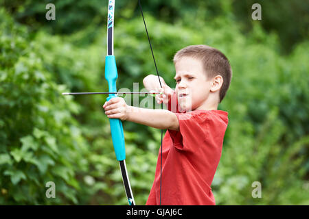 Little archer with bow and arrow outdoors Stock Photo