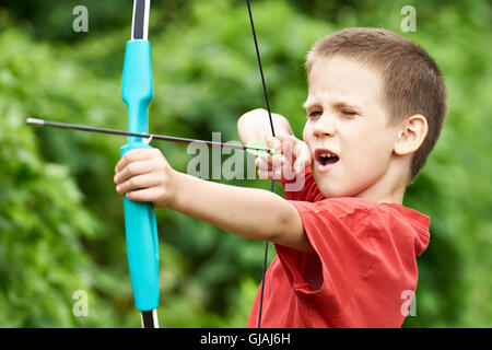 Little archer with bow and arrow outdoors Stock Photo