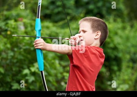 Little archer with bow and arrow outdoors Stock Photo