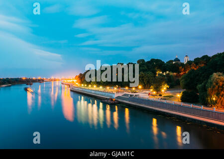 The Scenic Summer Evening View Of Sozh River, Illuminated Embankment And Ancient Greenwood Park, Cathedral Of St. Peter And Paul Stock Photo