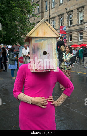 A performer with a birdhouse on her head promotes a show on the Royal Mile during the Edinburgh fringe Festival. Stock Photo