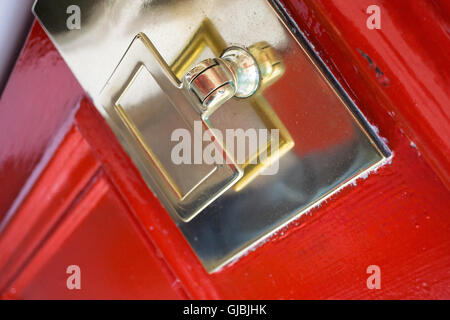 Traditional brass door knocker, on a bright red door Stock Photo