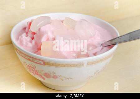 Milk flavoured shaved ice or snow cone or snowball with palm seed and coconut jelly isolated on wood Stock Photo