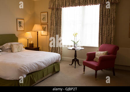 A chair and table in a bedroom at the Talbot Hotel in Malton, North Yorkshire, United Kingdom. The upscale hotel is in a former Stock Photo