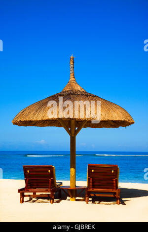 Beach in Mauritius with view over Indian Ocean with two beds and shade umbrella Stock Photo