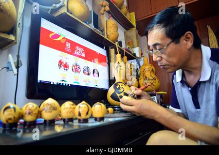 Liaocheng, Liaocheng, China. 15th Aug, 2016. Liaocheng,?CHINA?-?August?14?2016:?(EDITORIAL?USE?ONLY.?CHINA?OUT)?.Ji Zhenshan makes the electric ironing portrait of a Chinese Olympic gold medalist on the surface of egg-shaped gourd. Ji Zhenshan, a folk artist living in east ChinaÂ¡Â¯s Shandong Province, paints portraits of Olympic gold medalists on the surface of egg-shaped gourds celebrating Chinese athletesÂ¡Â¯ achievements at the on-going 2016 Rio Olympic Games. Ji has painted the portraits of Chinese champions including swimmer Sun Yang, diver Wu Minxia and pistol shooter Zhang Mengxue. Stock Photo