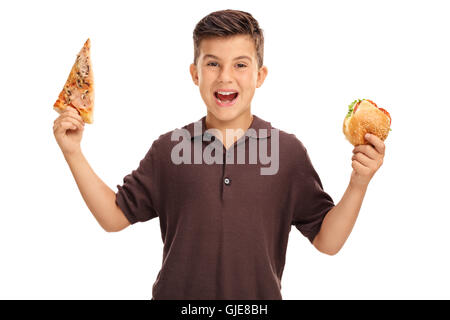 Cheerful kid holding a sandwich in one hand and a slice of pizza in the other isolated on white background Stock Photo