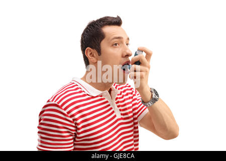 Young man using an asthma inhaler isolated on white background Stock Photo