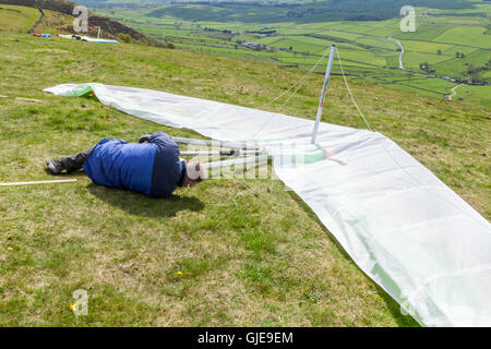 Person assembling or rigging a hang glider at Bradwell Edge, Derbyshire, Peak District, England, UK Stock Photo