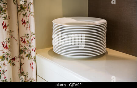 close up of plates on cupboard shelf Stock Photo