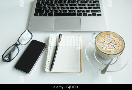 Office table with notepad, laptop and coffee cup.View from above with copy space. Stock Photo