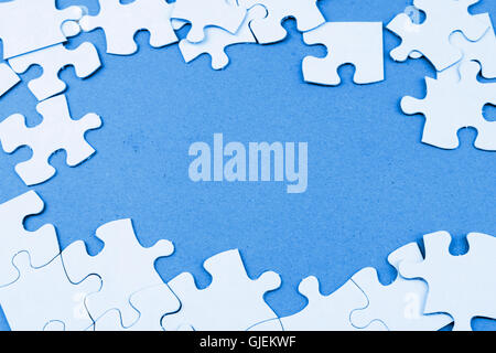 Loose jigsaw puzzle pieces on blue background Stock Photo