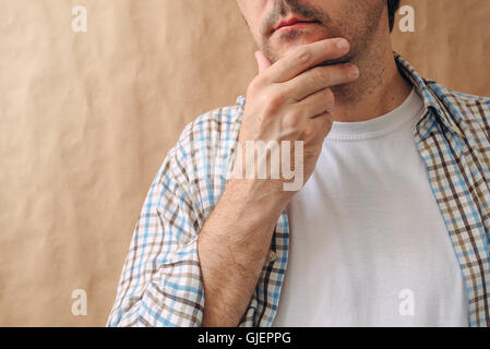 Man stroking chin and thinking deep thoughts, making tough decisions Stock Photo