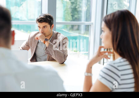 Thoughtful young businessman sitting on business meeting in conference room Stock Photo