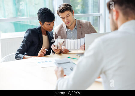 Group of young businesspeople having meeting at the table in modern office Stock Photo