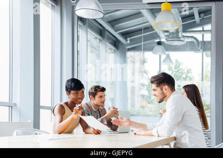 Group of young businesspeople discussing new project at business meeting in office Stock Photo