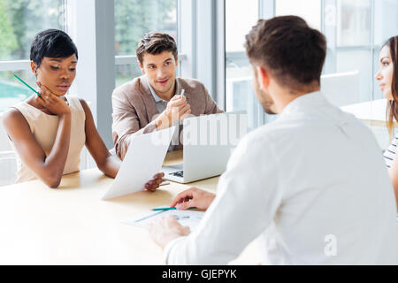 Group of young businesspeople working with laptop at meeting in office Stock Photo