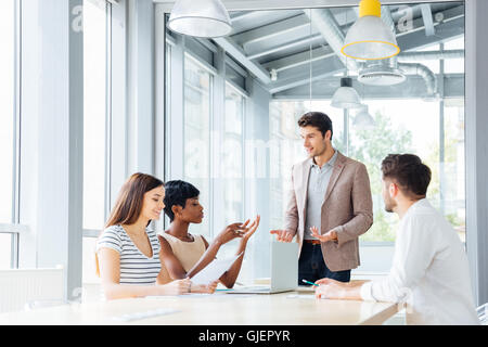 Group of smiling inspired young business people working together in office Stock Photo