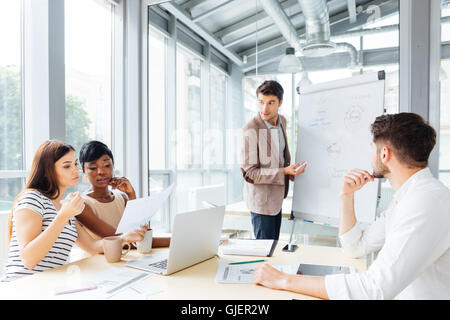 Handsome young businessman making presentation using flipchart in office Stock Photo