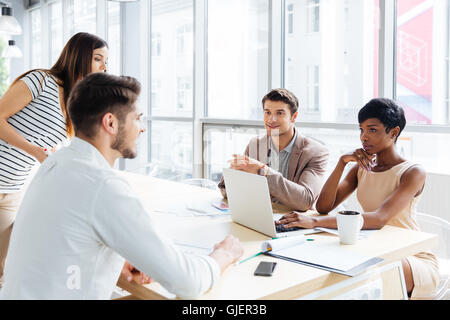 Successful young business people talking and working together in office Stock Photo