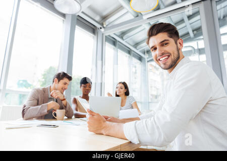 Smiling confident young businessman working and using tablet on business meeting in office Stock Photo